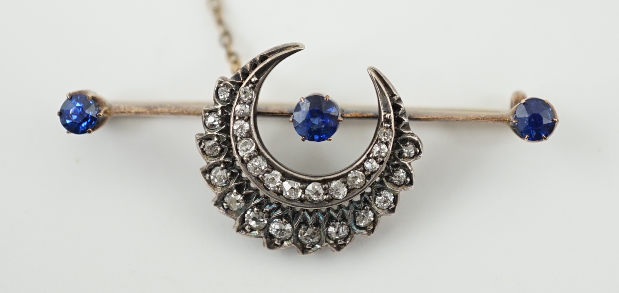 A Victorian gold and silver, three stone sapphire and diamond cluster set double crescent bar brooch